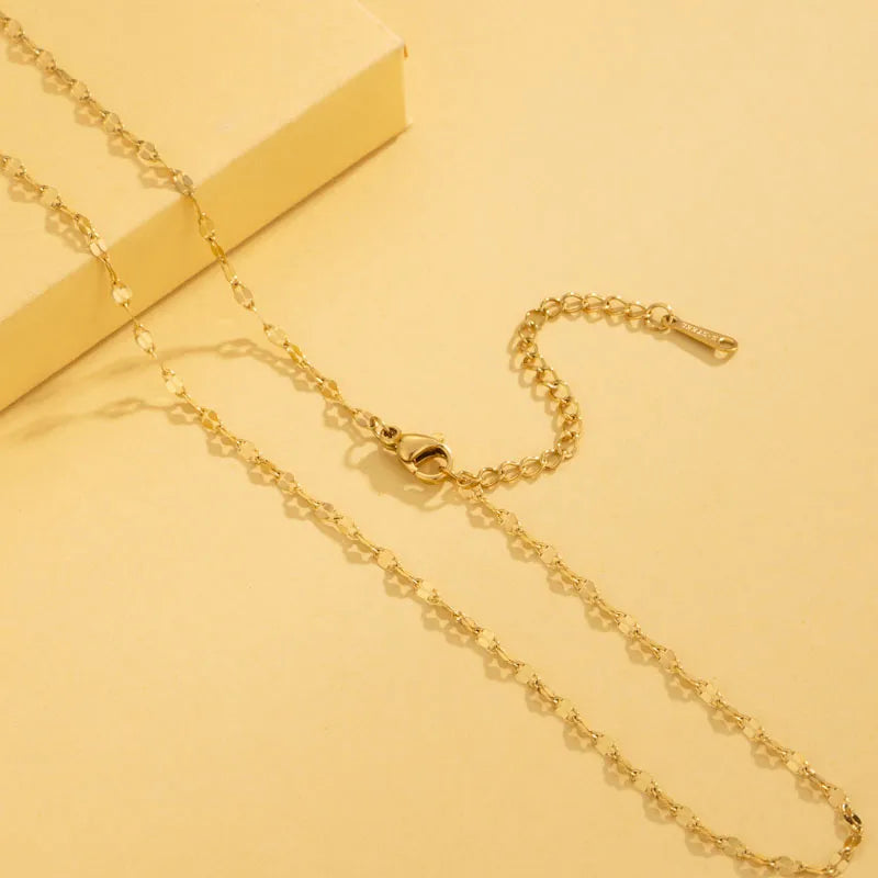 Gold chain necklace on a yellow background