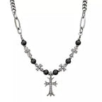 Necklace with black beads and silver cross pendant on a white background