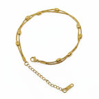 A gold-plated double-strand snake chain bracelet with polished oval bead accents and an adjustable lobster clasp with an extension chain.