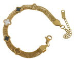 A gold-tone mesh bracelet with five clover-shaped links, three of which are filled with black enamel and one with a white inlay, photographed on a light off-white background.