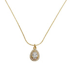 A gold chain necklace with a teardrop-shaped pendant featuring a clear central gemstone surrounded by a halo of small clear stones, displayed on a clean white background.