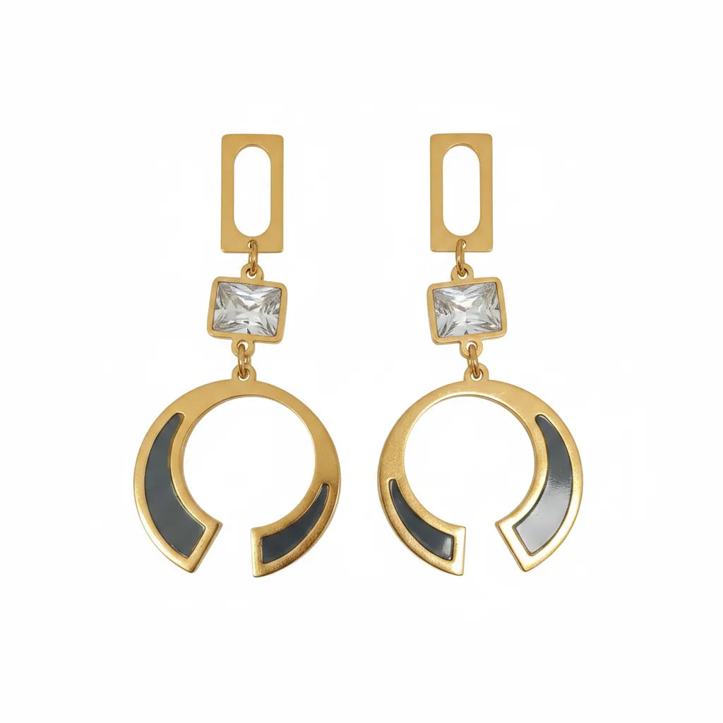 A pair of gold-tone statement dangle earrings with a rectangular cutout top, a clear square crystal, and a large open crescent-shaped drop featuring black inlay details, shown on a plain white background.