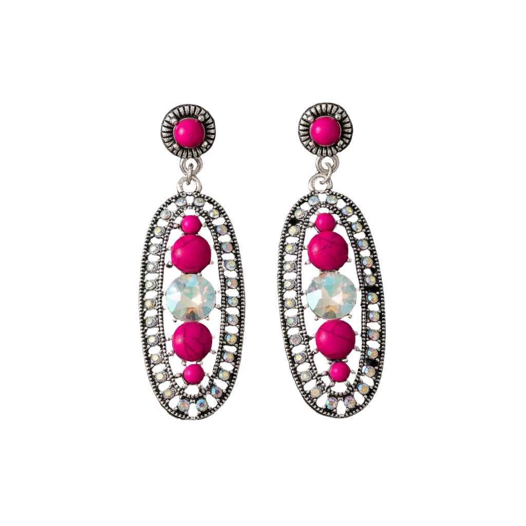 A pair of silver-toned dangle earrings with bright pink gemstones and a central iridescent white stone, displayed against a solid black background.