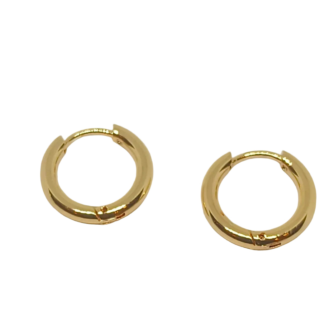 A pair of small gold huggie hoop earrings on a plain white background.