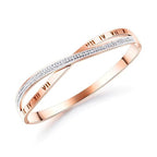 A rose gold bangle bracelet with a double-band design, featuring one band paved with small clear stones and the other engraved with Roman numerals, set against a plain white background.