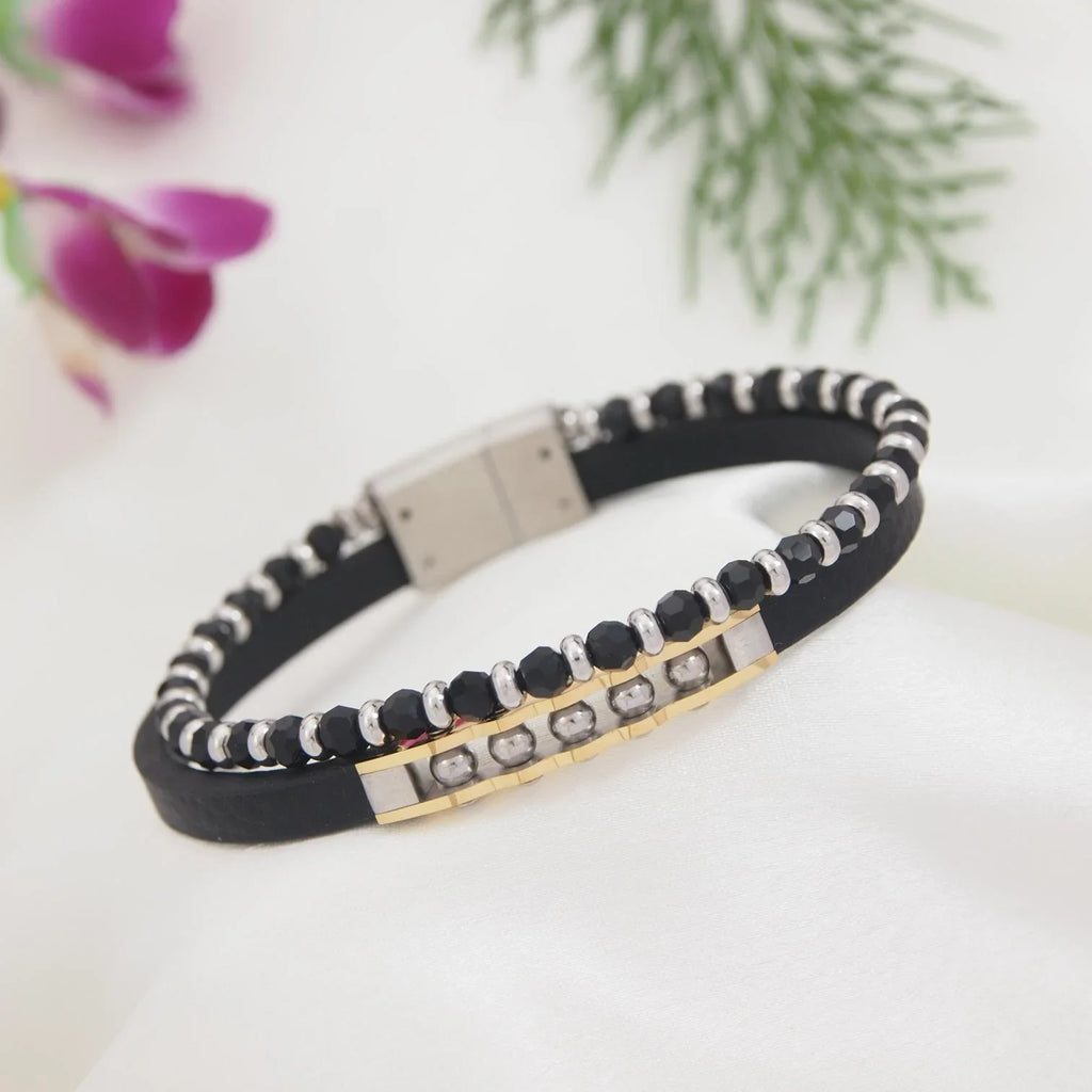 Black and white beaded bracelet with gold accents on a light background
