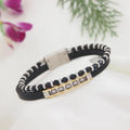 Black and white beaded bracelet with gold accents on a light background