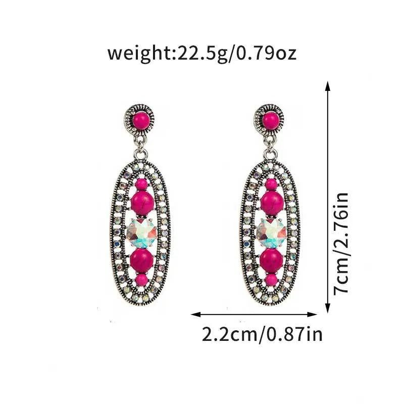 Pair of earrings with pink gemstones and measurements on a white background