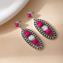 Pair of earrings with pink gemstones on a beige background