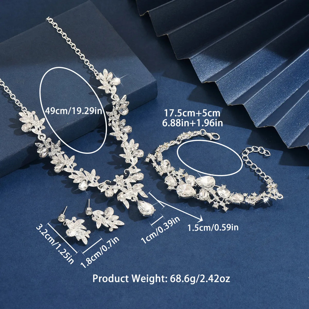 Silver jewelry set with necklace, bracelet, and earrings on a blue background with measurements.