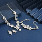 Silver jewelry set including necklace, bracelet, and earrings on a blue background