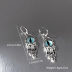 Pair of silver earrings with blue gemstones on a gray background, showing measurements and weight.