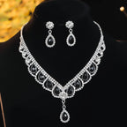 Necklace and earrings set with black stones and clear crystals on a black background