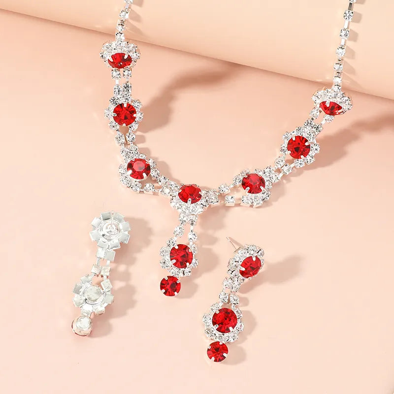 Jewelry set with red gemstones and silver accents on a beige background