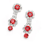 Pair of earrings with red gemstones on a white background