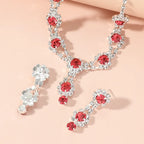 Jewelry set with red gemstones and silver accents on a beige background