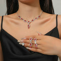 Jewelry set with necklace, earrings, and ring featuring red gemstones and silver accents.