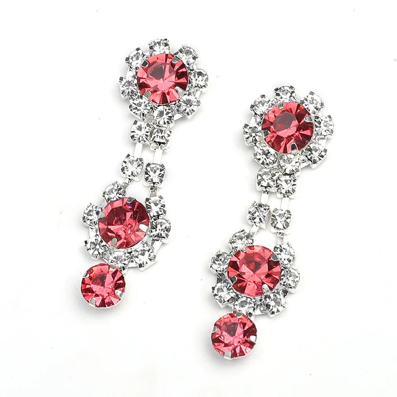 Pair of earrings with red gemstones on a white background