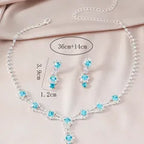 Jewelry set with necklace, earrings, and measurements on a light pink background