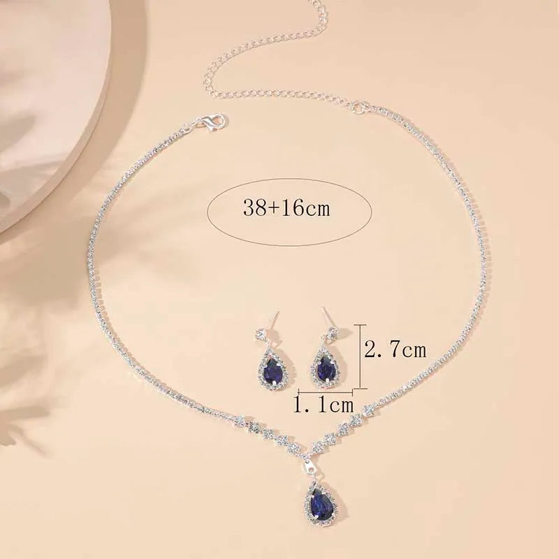 Jewelry set with necklace and earrings on a beige background, showing measurements.