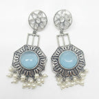 A pair of silver-toned statement dangle earrings with oval light blue center stones and dangling pearl-like beads, shown on a plain white background.