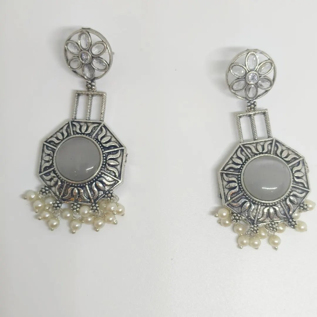 A pair of silver-toned dangle earrings with oval gray stone centers and clusters of small white pearls at the bottom, displayed on a plain white background.