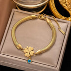 Evil's Eye Leaf Charm Snake Chain Bracelet in gold tone with a four-leaf clover charm and a small blue evil eye pendant, a stylish luxury fashion jewelry accessory.