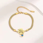 Evil's Eye Leaf Charm Snake Chain Bracelet featuring a polished gold plated snake chain with a four-leaf clover charm and a small blue evil eye charm, elegant fashion jewelry.