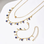 Gold necklaces with blue evil eye charms on a white surface