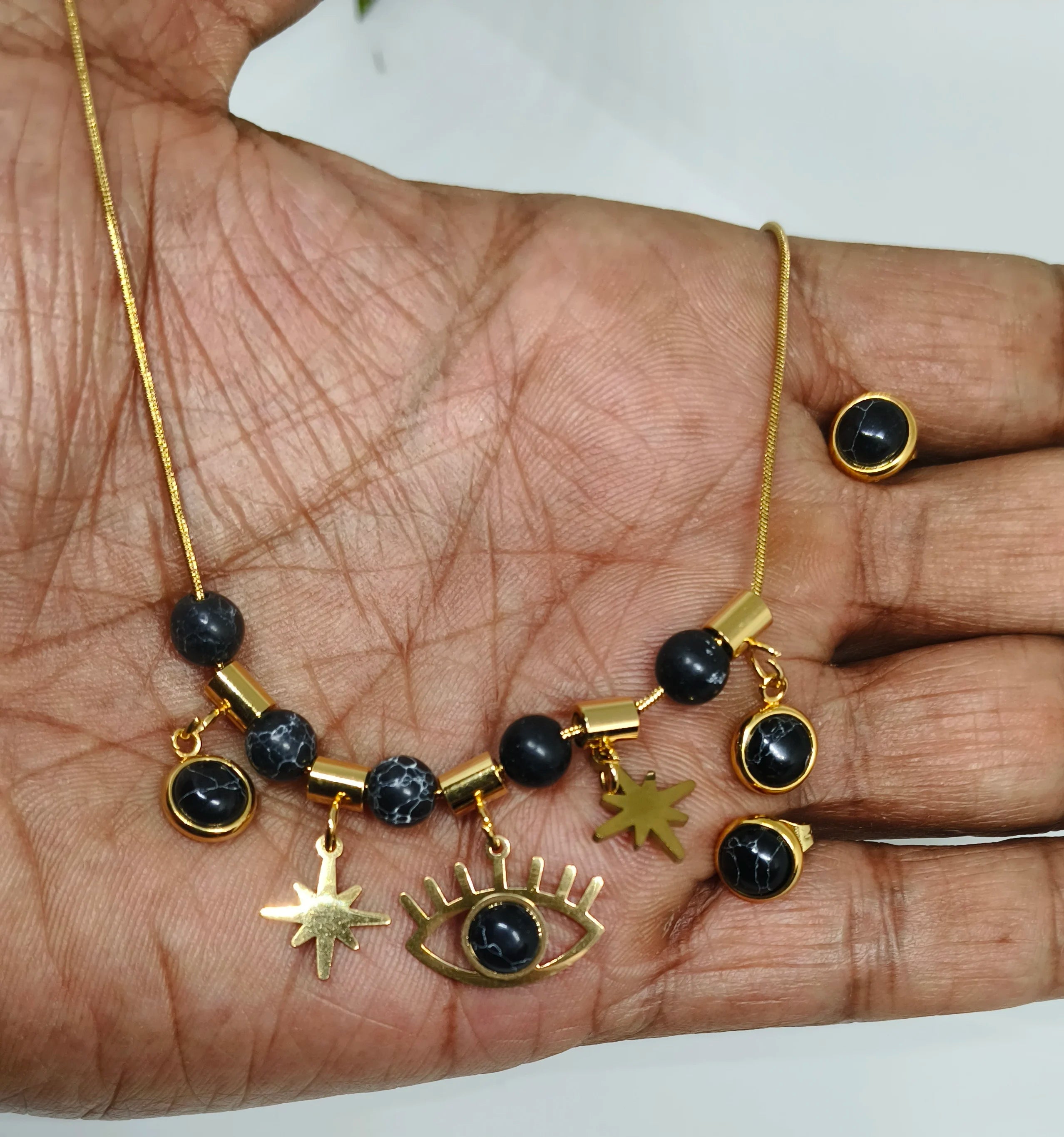 Gold and black jewelry set on a hand