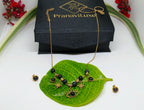 Jewelry set with necklace and earrings on a green leaf, branded 'PranaviLuxe'.