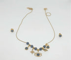 Gold necklace with blue beads and eye-shaped charms on a white background