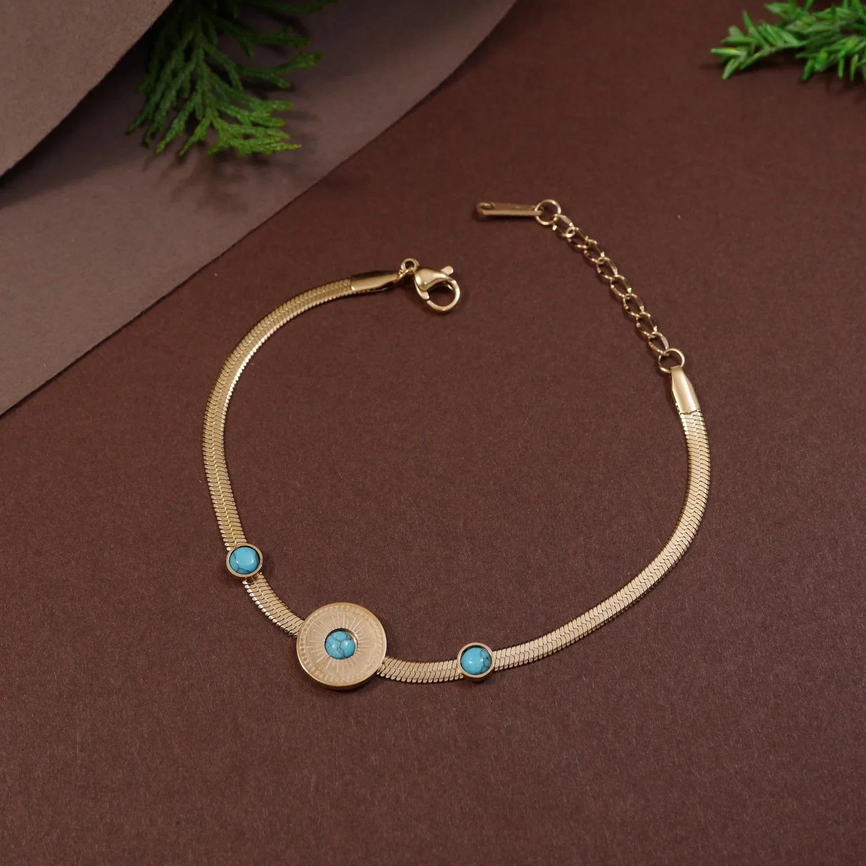 Gold bracelet with turquoise stones on a brown background