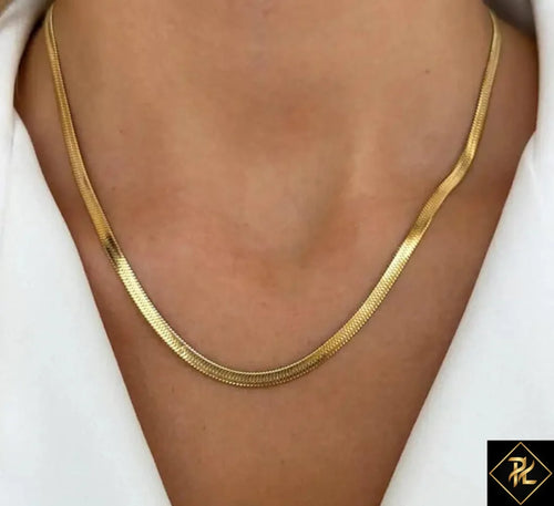 Gold necklace on a person wearing a white shirt