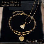 Gold necklace and bracelet gift set displayed on a black presentation box. The set includes a delicate gold chain necklace with a small pavé-fan pendant and a matching gold chain bracelet with a heart-shaped charm and bar-link detail.