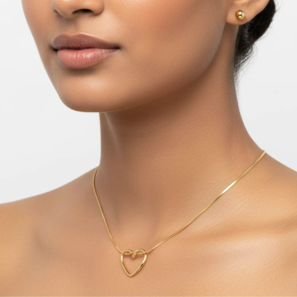 Gold necklace and earring set by PranaviLuxe, featuring a heart-shaped pendant on a snake chain and matching stud earrings