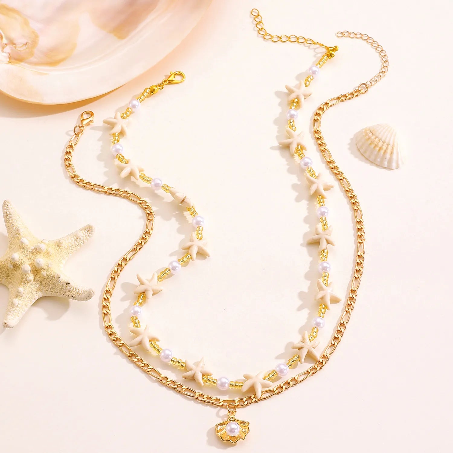 Gold necklace with starfish and pearl details on a light background