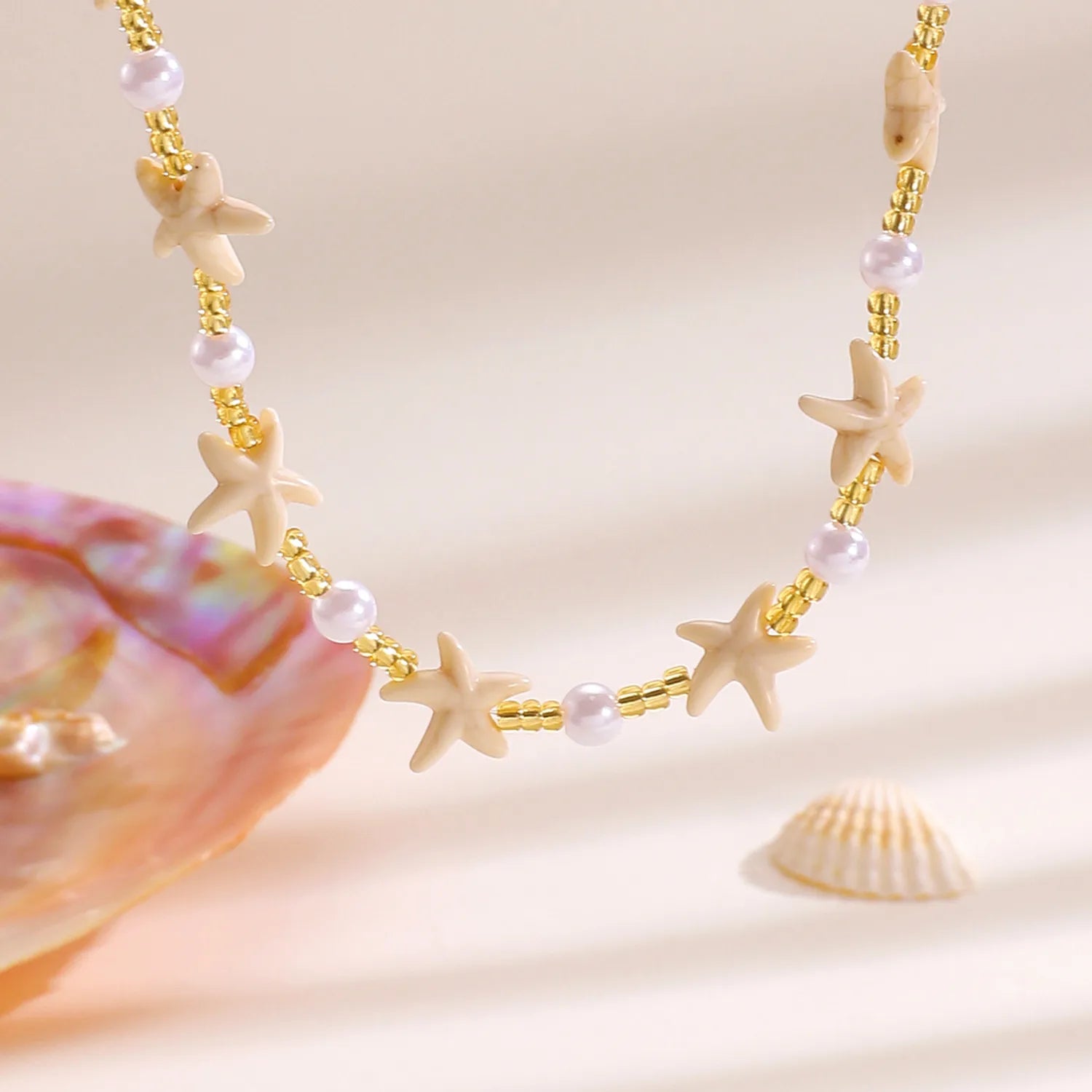 Necklace with starfish and pearl beads on a beige background