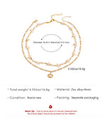 Gold necklace with star and heart charm on a white background