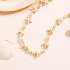 Necklace with starfish and pearl details on a beige background