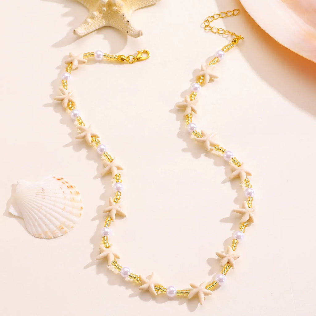 Necklace with starfish and pearl details on a beige background