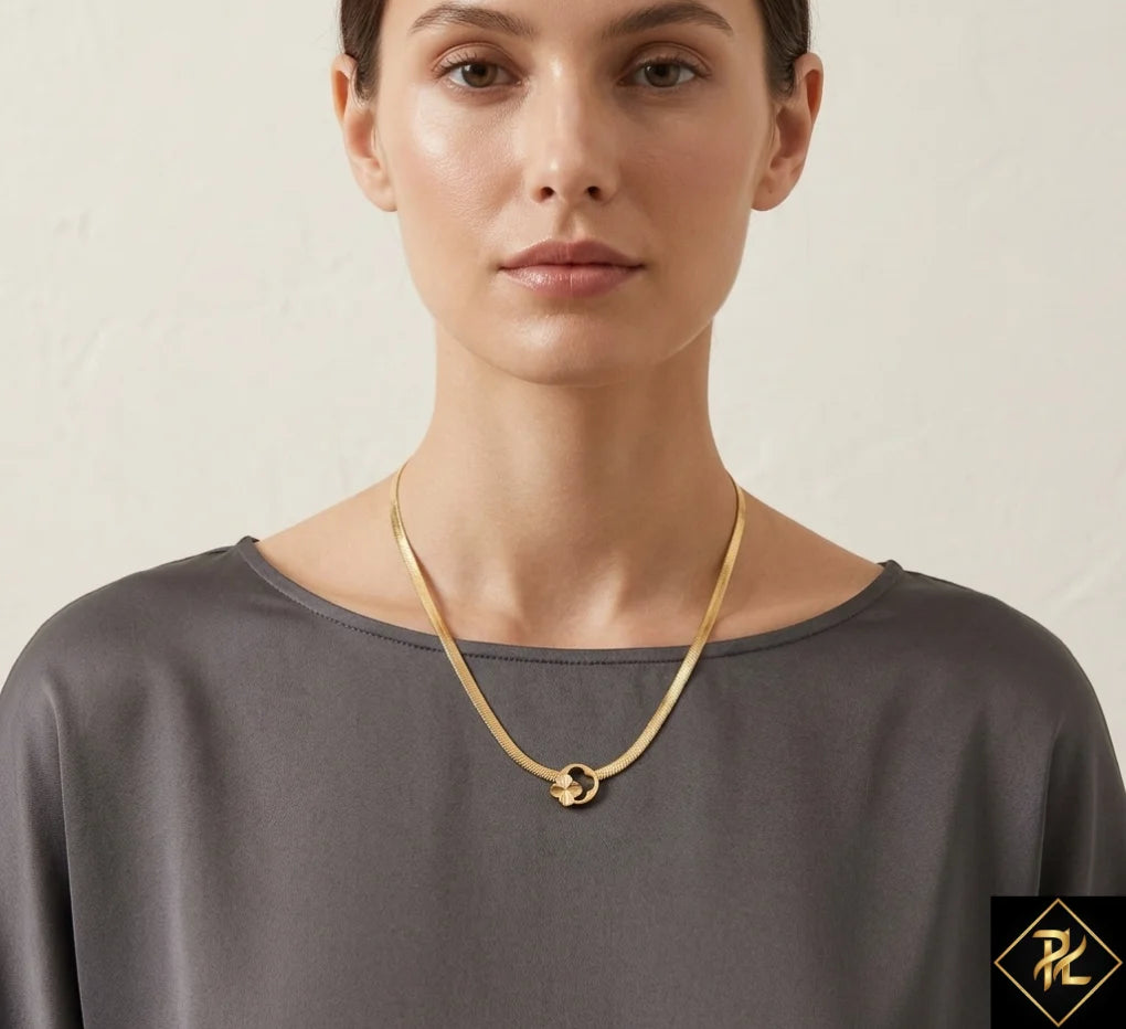 Woman wearing a gold necklace against a neutral background