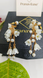 Pearl and gold earrings on a black card with 'PranaviLuxe' branding.