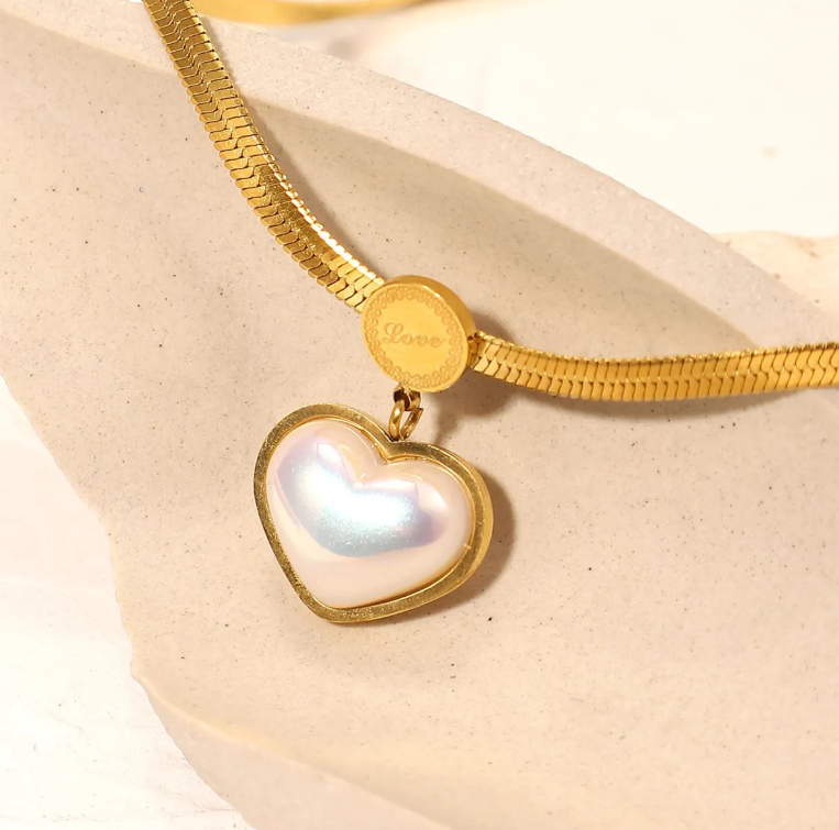 Love Heart Shaped Pearl Pendant Necklace with a gold plated chain and a heart-shaped pearl pendant framed in gold, featuring a delicate "Love" engraving on the clasp.