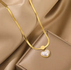 Love Heart Shaped Pearl Pendant Necklace featuring a gold-toned chain with a pearl heart-shaped pendant, displayed on a silky beige fabric and elegant jewelry box backdrop.