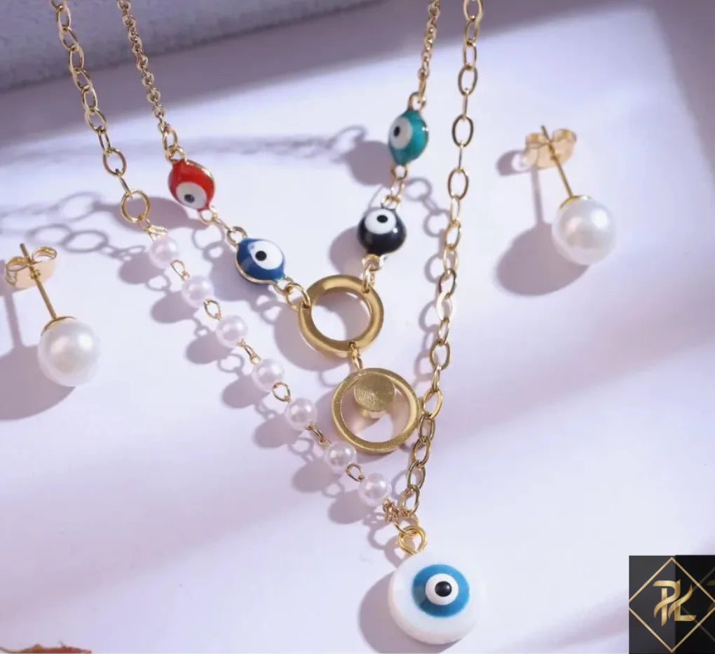 Gold necklace with eye-shaped beads and matching earrings on a white background