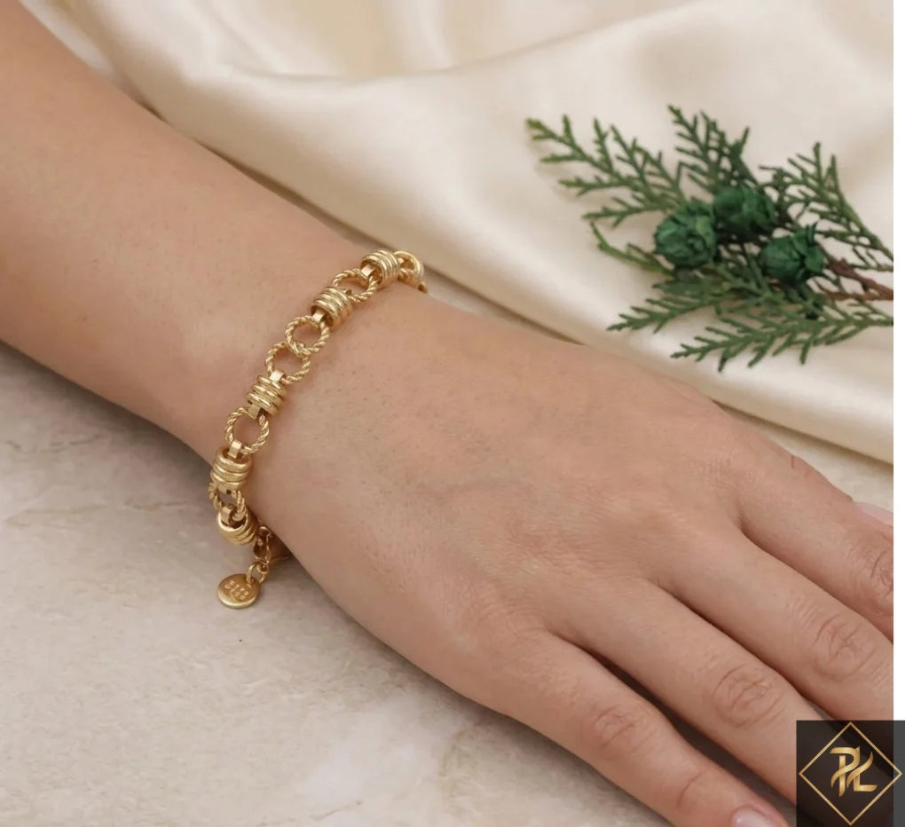 Gold bracelet on a hand with a neutral background