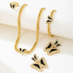Gold chain necklace and butterfly earrings on a white surface