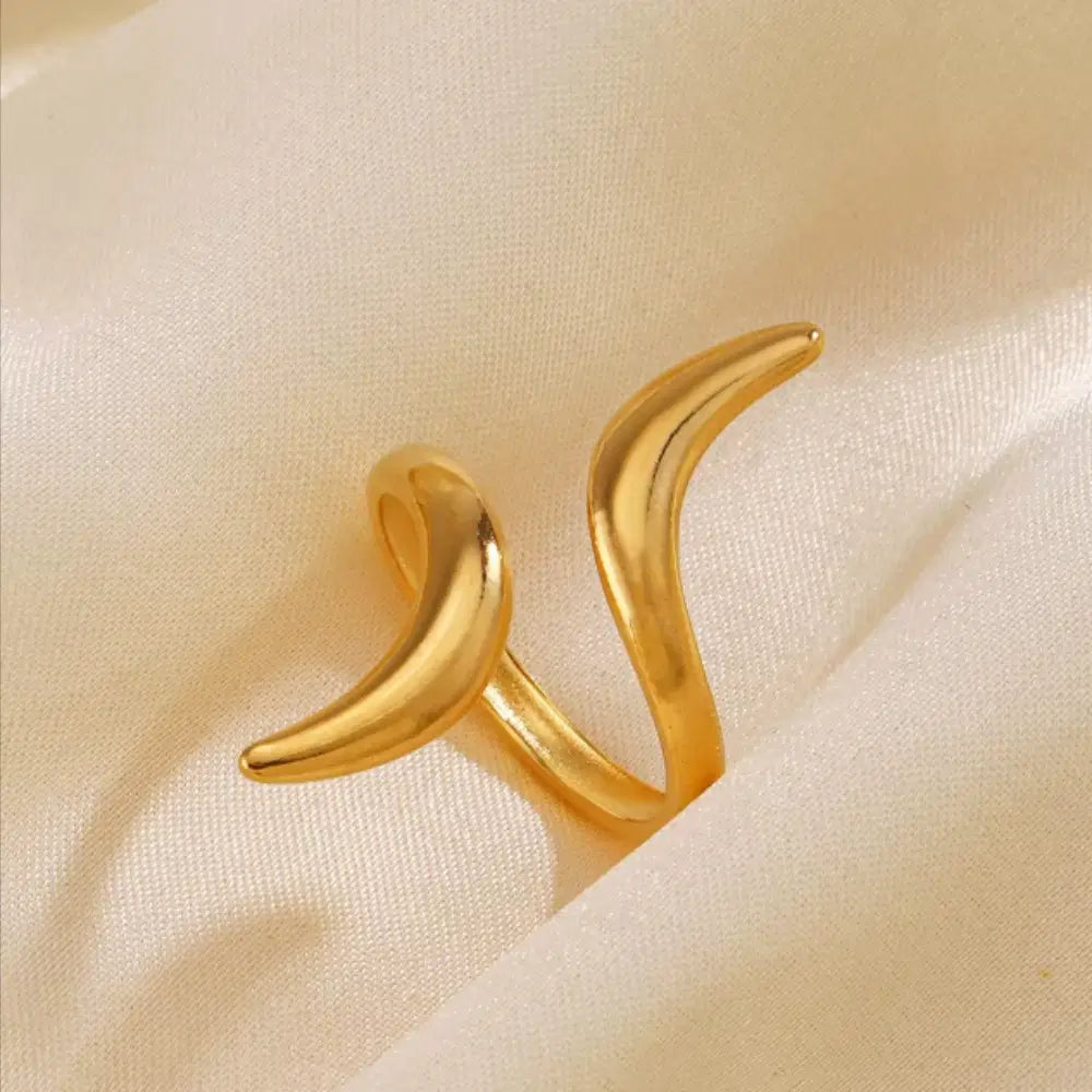 Gold crescent moon-shaped earrings on a beige fabric background