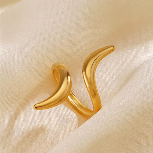 Gold crescent moon-shaped earrings on a beige fabric background